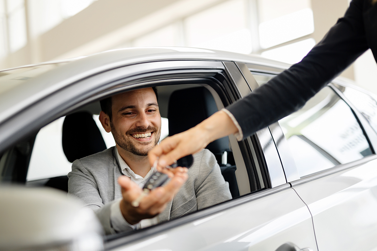 Man in car being handed car keys