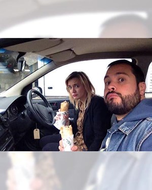 Selfie of two customers sat in their car eating wraps and looking sad