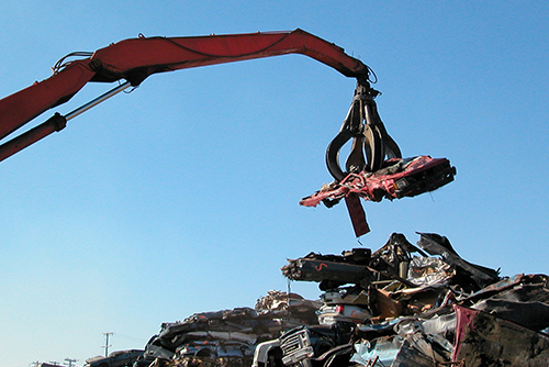 Crane with a grab holding a scrap car