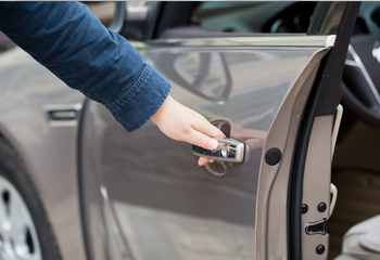 Person's hand on car door handle opening it