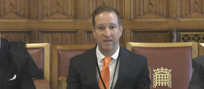 Photo of CarTakeBack's Ken Byng wearing a suit speaking in Parliament